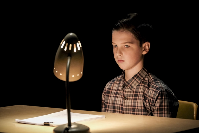 Young Sheldon Cooper looking serious with a desk lamp