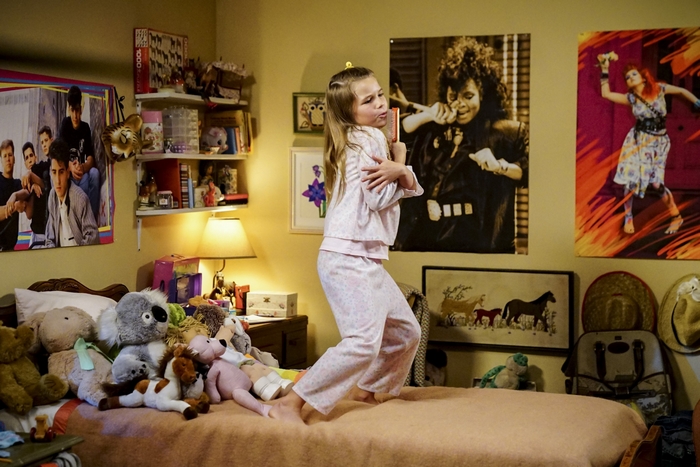Missy Cooper playfully singing on her bed
