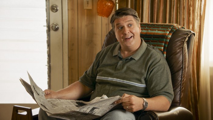 George Cooper from Young Sheldon holding a newspaper