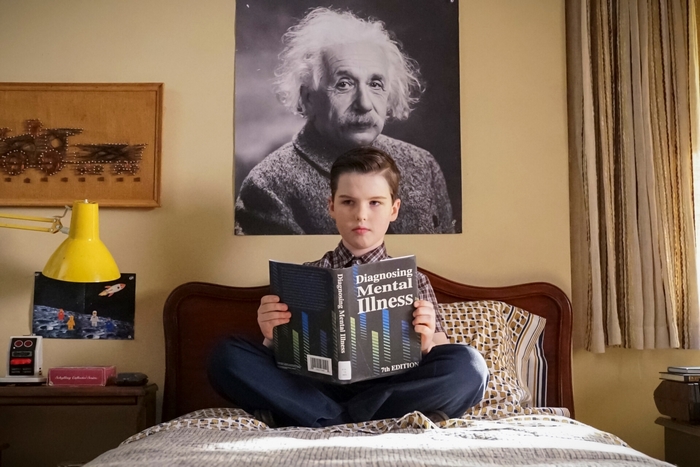 Young Sheldon reading 'Diagnosing Mental Illness' book