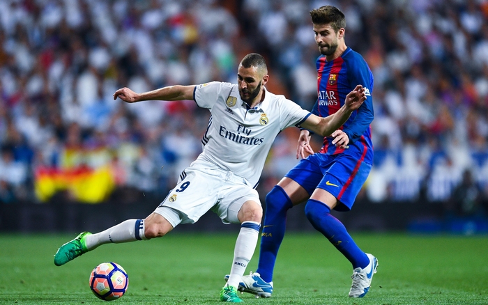 Karim Benzema battles Gerard Pique in soccer match