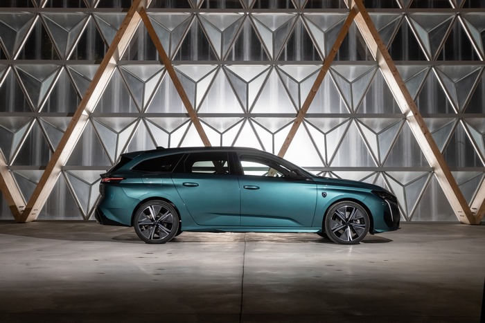 Teal Peugeot 308 SW Hybrid against geometric wall