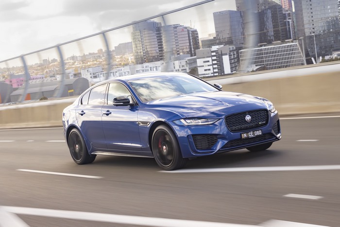 Luxury blue Jaguar XE P300 AWD on city highway