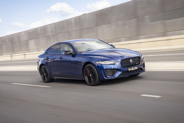 Blue Jaguar XE luxury car driving on highway