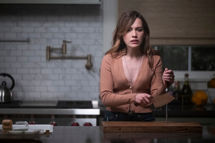 Victoria Pedretti holding a knife in the kitchen from You