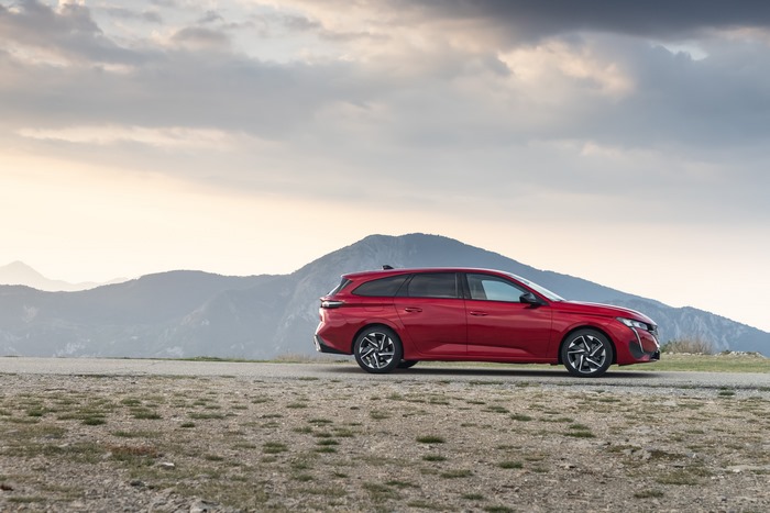 Red Peugeot 308 SW GT in mountain landscape