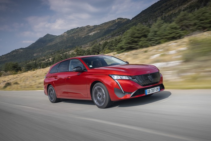 Red Peugeot 308 SW GT driving on mountain road