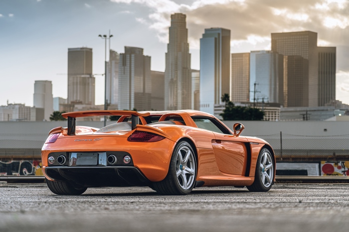 Orange Porsche Carrera GT against a City Skyline