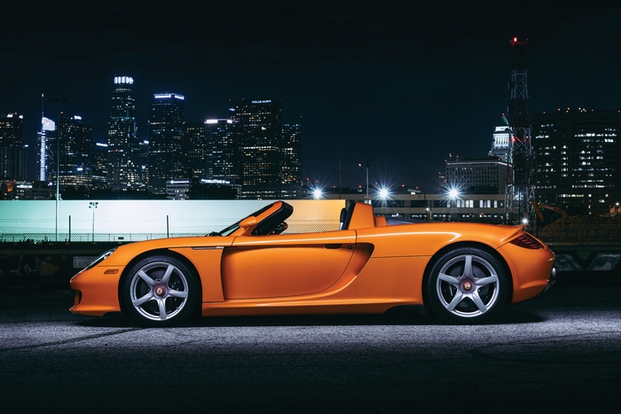 Orange Porsche Carrera GT 4K against City Skyline