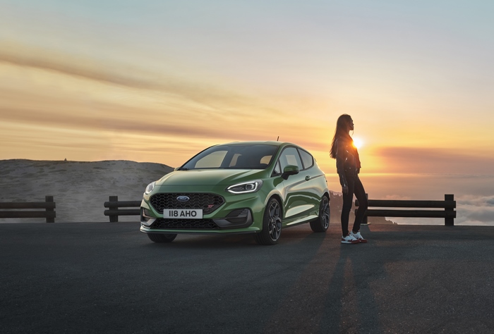 Green Ford Fiesta ST and woman at sunset