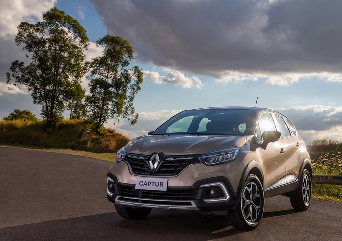 Renault Captur SUV on a road with sun and trees