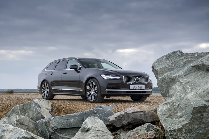 Luxury Volvo V90 parked by large rocks