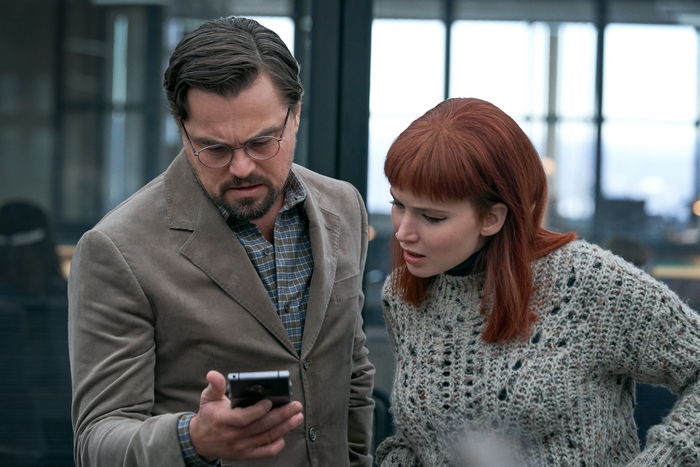 Leonardo DiCaprio and Jennifer Lawrence looking at a phone in Don't Look Up
