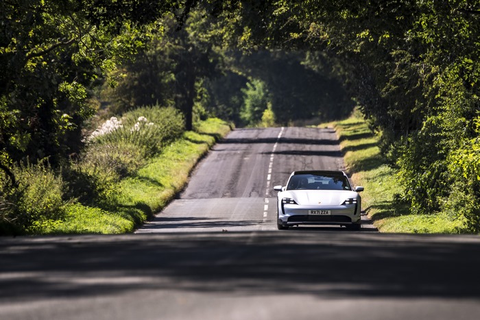 Porsche Taycan 4S on a sunny tree-lined road