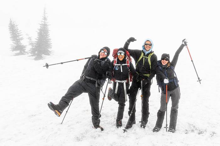 Joyful group hiking in a snowy, foggy landscape