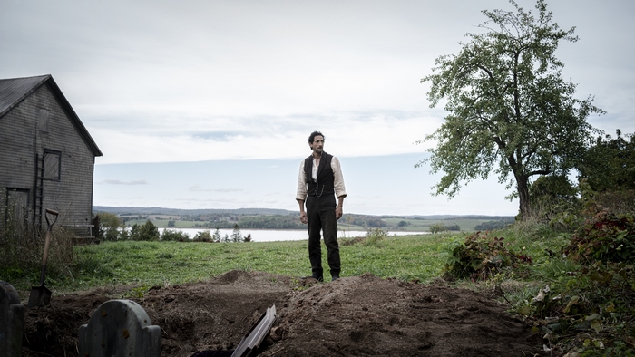 Adrien Brody standing by a grave in Chapelwaite