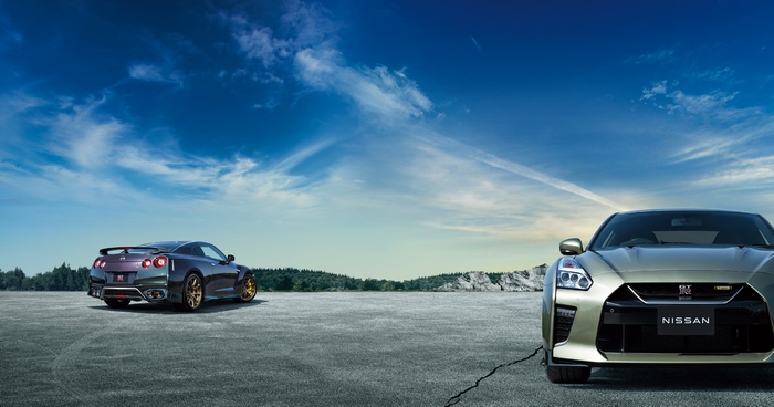 Two Nissan GT-R R35 sport cars on tarmac.