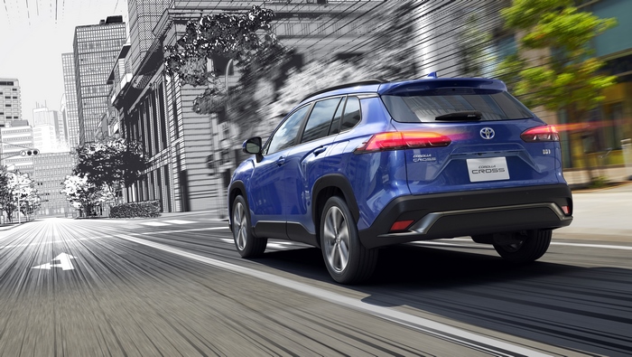 Blue Toyota Corolla Cross SUV driving in stylized city
