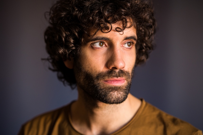 Close-up portrait of actor Tamar Novas looking sideways