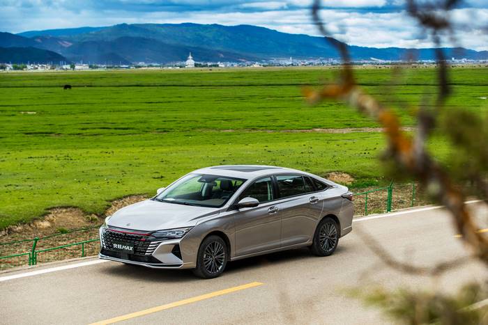 Silver Dongfeng Aeolus Yixuan compact car in a scenic landscape
