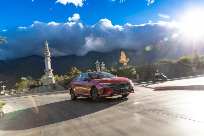 Red Dongfeng Aeolus Yixuan compact car on scenic road