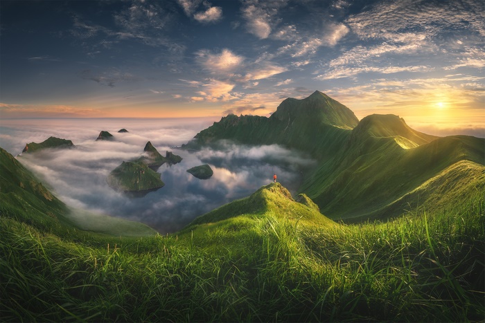 Panoramic view of misty mountains and islands at sunrise