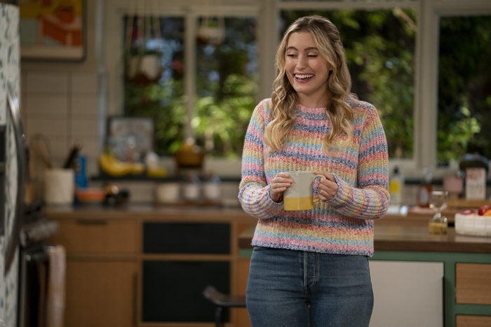 Olivia Macklin smiling in a colorful sweater in Pretty Smart