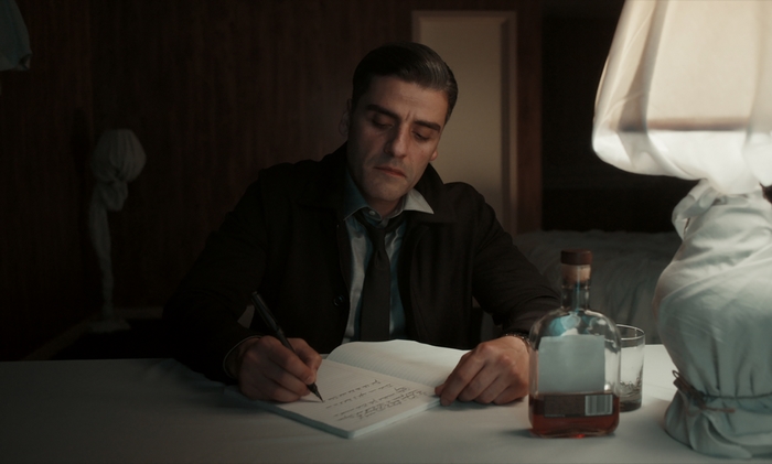 Oscar Isaac writing a journal in The Card Counter
