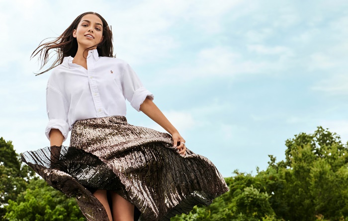 Rachel Zegler in white shirt and shimmering pleated skirt