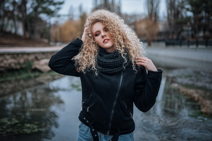 Blonde model with curly hair in black jacket
