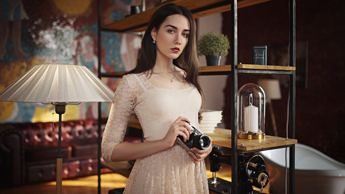 Brunette model in lace dress holding camera