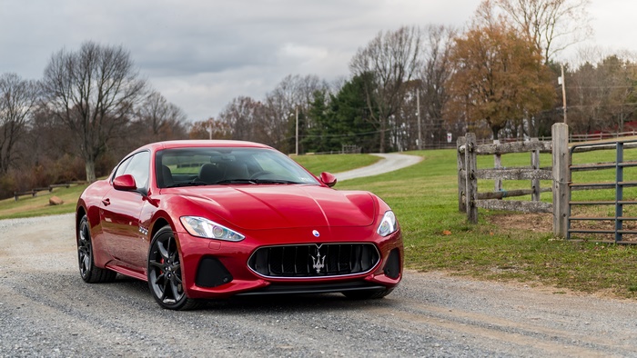 Red Maserati GranTurismo sport car on a gravel road 4K