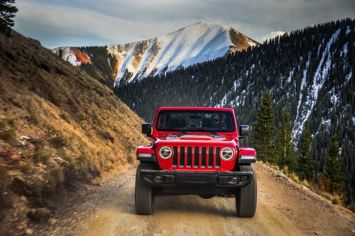 Red Jeep Wrangler on a snowy mountain trail