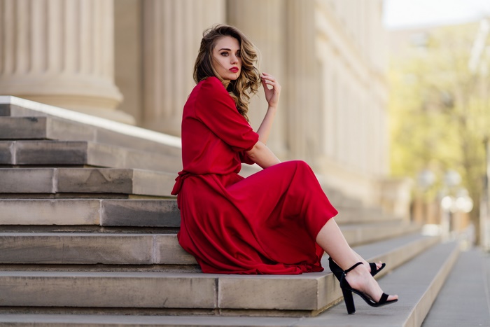 Elegant Model in Red Dress Sitting on Stone Steps