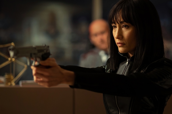 Maggie Q aiming a gun in The Protégé
