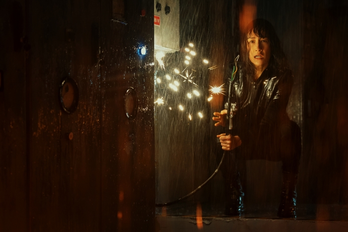The Protégé: Maggie Q with sparking wire in the rain