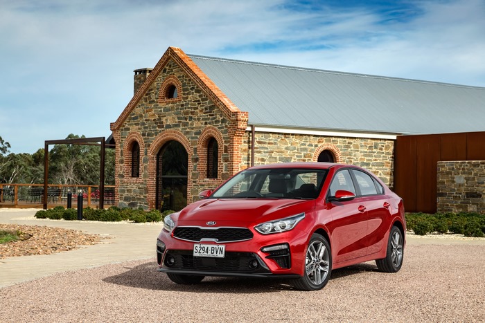Red Kia Cerato Sport Plus at a stone building