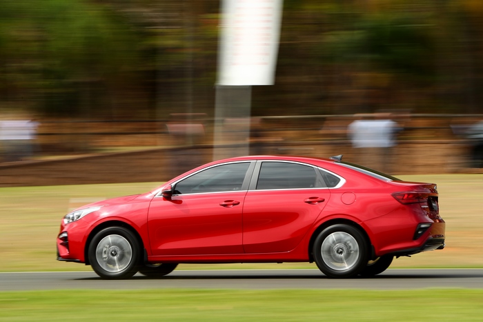 Red Kia Cerato compact car in motion