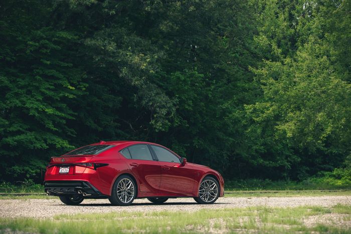 Red Lexus IS 500 F SPORT Performance parked by green trees