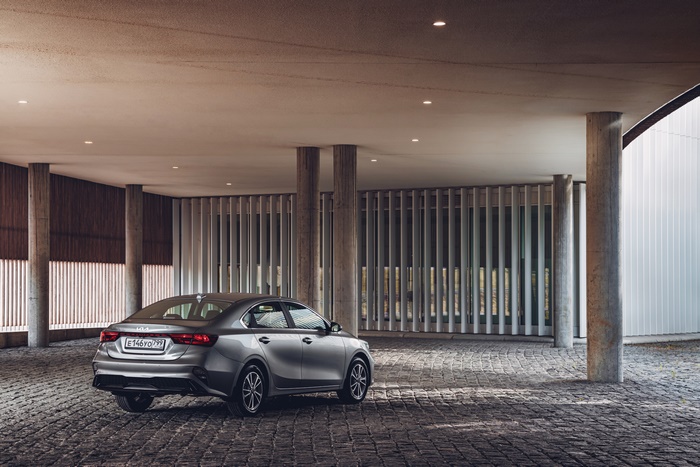 Kia Cerato compact car in modern architectural setting