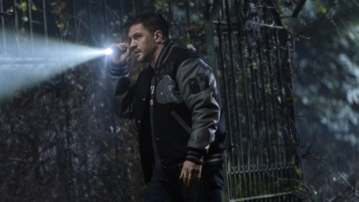 Tom Hardy as Eddie Brock with flashlight in Venom