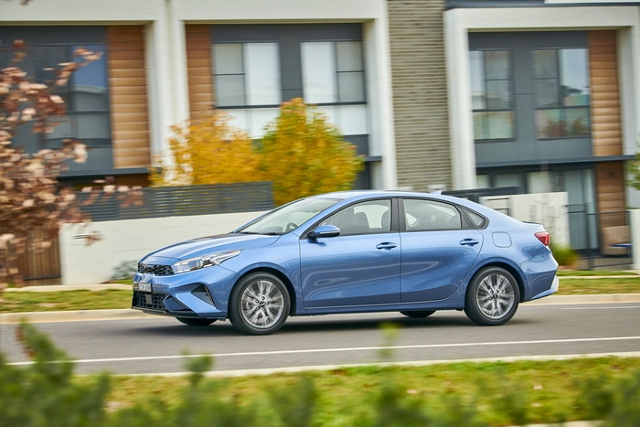 Blue Kia Cerato Sport Plus compact car driving on road