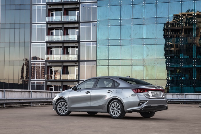 Silver Kia Cerato S compact car with modern building backdrop
