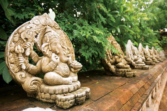 Row of Ganesh statues in a lush garden