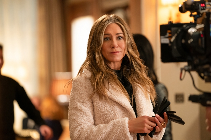 Jennifer Aniston on set in a cream coat