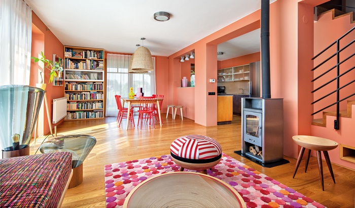 Vibrant peach-walled living and dining room with fireplace