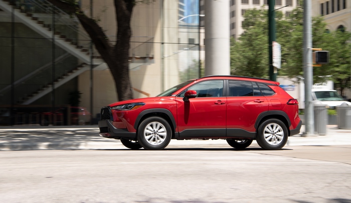 Red Toyota Corolla Cross LE AWD SUV driving