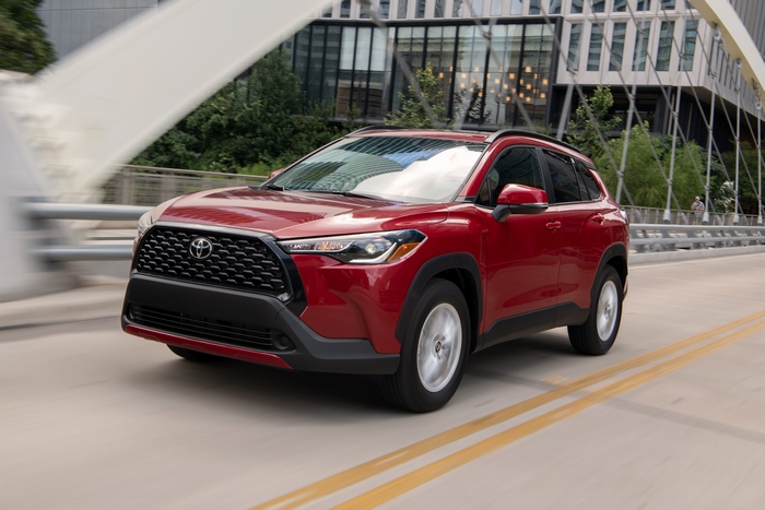 Red Toyota Corolla Cross SUV driving on road