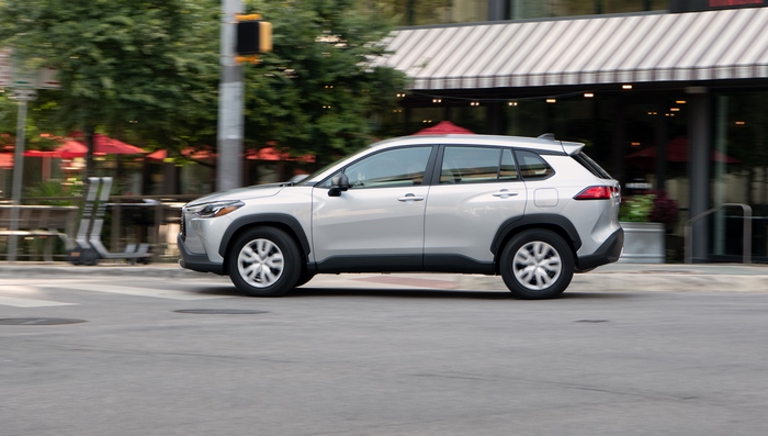 Silver Toyota Corolla Cross SUV driving on city street