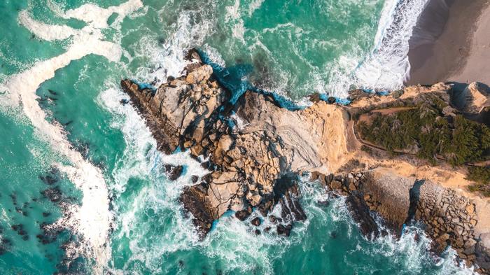 Aerial view of a beautiful turquoise ocean and rocky beach